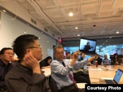 哈佛大学"改革开放40年:挑战和机遇"系列研讨,无法到场的天则经济研究所所长盛洪教授的视频发言,学者吴思举着电脑播放视频(盛洪推特照片)