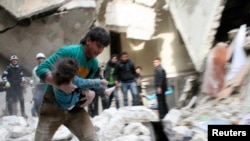 2月2号阿萨德军队轰炸阿勒颇,一名男子怀抱从瓦砾下挖出的一名受伤的孩子。