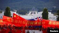 亲中国的支持者在澳大利亚堪培拉议会大厦前举旗帜欢迎中国总理李克强到访澳大利亚。(2017年3月23日)