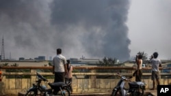 资料照片:在中国人经营的工厂受到攻击后,仰光莱达雅工业园区冒出滚滚浓烟。(2021年3月14日)