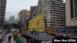 高铁西九龙站附近一个繁忙路口,工人们正在准备新路牌吊装作业 。(美国之音记者申华 拍摄)