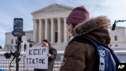 美国最高法院门前,一名女士举着“保留TikTok" 的标语牌。
