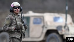 Американський солдат стоїть перед військовою машиною на базі у Графенвері, південна Німеччина, 28 березня 2023 року. Прокуратура Німеччини заявила 18 квітня 2024 року, що двоє чоловіків були заарештовані за підозрою в шпигунстві на користь Росії. (Фото: Christof STACHE / AFP)