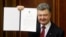 Ukraine's President Petro Poroshenko shows a signed landmark association agreement with the European Union during a session of the parliament in Kyiv, Sept. 16, 2014.