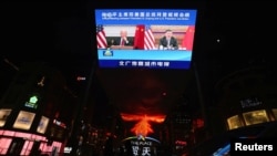 2021年11月16日,北京的户外显示屏上播放中国中央电视台有关国家主席习近平与美国总统拜登视频会议的报道。