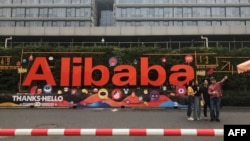 资料照:人们在阿里巴巴位于杭州的总部前合影。(2019年9月4日)