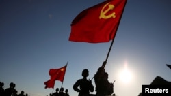 中国解放军军人在内蒙古朱日和训练基地准备参加阅兵,庆祝解放军建军90周年。中共党旗在前,国旗居中,军旗在后(2017年7月30日)