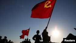 中国解放军军人在内蒙古朱日和训练基地准备参加阅兵,庆祝解放军建军90周年。中共党旗在前,国旗居中,军旗在后(2017年7月30日)