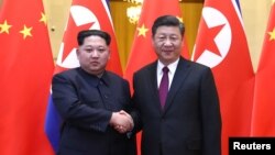 Lãnh tụ Triều Tiên Kim Jong Un và Chủ tịch Trung Quốc Tập Cận Bình bắt tay trong Đại lễ đường Nhân dân ở Bắc Kinh, Trung Quốc, trong bức hình được công bố vào ngày 28 tháng 3, 2018.