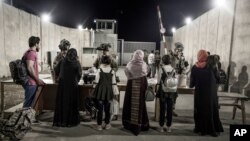 美国海军陆战队公布的照片显示,美国陆军第82空降师的军人在喀布尔哈米德·卡尔扎伊国际机场检查被撤离人员。(2021年8月25日)