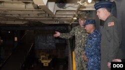 驻日美军司令马丁内斯空军中将(右)陪同日本海上自卫队官员参观美国海军日耳曼城号登陆舰