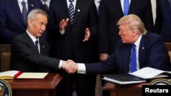 资料照片:美国总统特朗普与中国副总理刘鹤在白宫签署美中第一阶段贸易协议。(2020年1月15日)