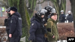 2024 年 2 月 17 日俄罗斯反对派领导人阿列克谢·纳瓦尔尼在北极死亡一天后,俄罗斯圣彼得堡警察抓捕前去政治镇压受害者纪念碑前给纳瓦尔尼献花的民众。图为一名男子被警察带走。