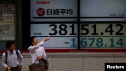 2024年9月30日,日本东京一家股票交易所外的电子屏幕显示下跌的日经平均指数。