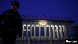 中国全国人民代表大会开幕前,一名警察在日出前守在北京的人民大会堂外。(2025年3月5日)