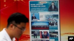 北京地铁外,一名男子走过宣传中国国家主席习近平提出的“一带一路”倡议的广告牌。(2018年8月28日)