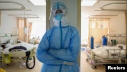 武汉红十字会医院隔离病房里一名疲劳的医护人员站着休息一下。(2020年2月16日)