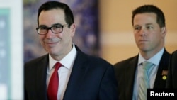 美国财政部长姆努钦(左)和美国经贸代表团成员离开北京一家酒店前去与中方谈判人员举行贸易谈判。(2018年5月3日)