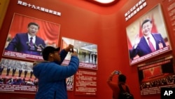 2018年11月15日,北京中国国家博物馆举办中国改革开放40周年展览突出习近平主席,参观者用手机拍照。