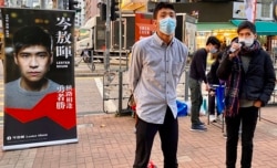 12港人关注组成员、本土派社运人士邹家成(左)与荃湾区议员岑敖晖,12月19日在大围港铁站外摆街站。 (美国之音/汤惠芸)
