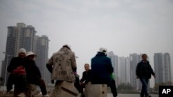 资料照:陕西省西安市一处新建居民区附近的农民工中午休息吃午餐。