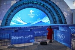 一名女子在给北京冬奥会设立的颁奖台拍摄照片。(2022年1月3日)