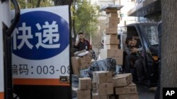 中国“光棍节”当天,北京街头快递小哥在分发运送包裹(2019年11月11日)