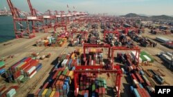 资料照:中国山东省青岛一个港口上的起重机、龙门吊车和集装箱。(2018年11月8日)