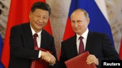 资料照:俄罗斯总统普京与中国领导人习近平在克里姆林宫参加一个签字仪式后握手。(2017年7月4日)