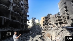 击毙黎巴嫩真主党领导人纳斯鲁拉后,以色列持续对黎巴嫩境内的“数十个”真主党目标展开空袭。图为一名男子回到纳斯鲁拉遭击毙的街区附近拍摄照片。(法新社:2024年9月29日)