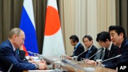 资料照片:2014年2月8日,俄罗斯总统普京(左)和日本首相安倍(右)在俄罗斯索契会晤。