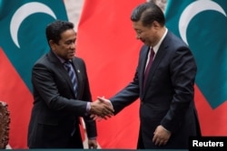 2017年12月7日,马尔代夫总统亚明在中国北京人民大会堂签署文件后,与中国国家主席习近平握手。