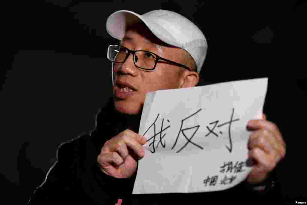 2018年2月28日,在北京接受路透社采访时,中国维权人士胡佳手持标语“我反对”(2018年2月28日)。在两会期间被送出北京度假的异议人士胡佳表示,控制措施非常普遍,尽管当局努力让他和其他人保持沉默,他仍会继续发表意见。他说,明确将一党制合法化的条款和废除两期任期限制都是违宪的。他说:“限制任期是唯一对最高领导者进行权力制衡的机制,他们最多只能有10年的领导权。这个一旦被取消,就不会有任何制衡机制。他可以任职超过10年,甚至一辈子。”  