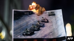 在香港维多利亚公园参加纪念六四事件31周年的一名男子手持天安门广场“坦克人”的照片。(2020年6月4日)