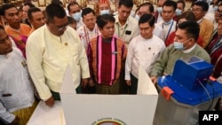 缅甸联邦选举委员会成员在仰光展示未来选举中将使用的投票机。(法新社:2023年9月5日)