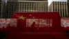 资料照:香港主权移交26周年纪念期间,中国国旗和香港区旗高挂香港街道大楼,旗帜后有行人走过天桥。(美联社,2023年6月27日)