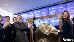 瑞幸咖啡首席执行官钱治亚(右)和非执行董事长陆正耀(左)在美国纽约纳斯达克市场敲响了公司股票上市交易的钟声(2019年5月17日)。