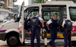 两名香港国安法被告李宇轩及陈梓华8月19日出庭认罪,大批穿着防弹背心的警员在高等法院外戒备 (美国之音/汤惠芸)