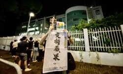 有市民高举苹果日报26周年报庆的头版广告,支持该报编采人员。 (美国之音/汤惠芸)