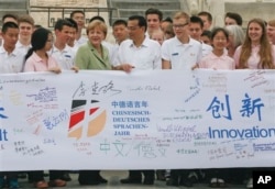 李克强与德国总理默克尔在北京天坛同中德两国高中生在一起(2014年7月7日)