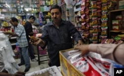 在印度首都德里市中部一个名为格罗尔巴格的地区,一个家庭商店的店主和顾客讨价还价(2011年11月24日)