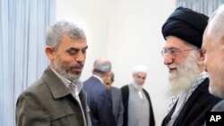 2012年2月12日,伊朗最高领袖哈梅内伊(右)于2月12日在德黑兰举行的一次会议上,向已身亡的哈马斯领导人辛瓦尔致意。(伊朗最高领袖办公室/美联社发布)
