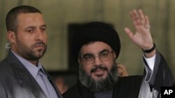 资料照片:黎巴嫩真主党领导人纳斯鲁拉在保镖卡纳什(左)的保护下在贝鲁特向支持者招手。(2006年9月22日)