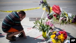 在南卡罗来纳州教堂枪击案出事地点附近的临时追悼场所,有人哀悼(2015年6月18日)
