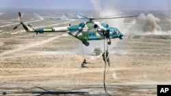 资料照片:俄罗斯国防部新闻局公布的照片显示,在中俄宁夏联合军演期间,军人们从一架中国军用直升机索降。(2021年8月13日)