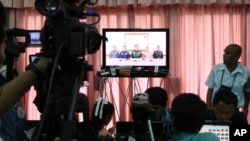 5月22日,泰国记者和外国媒体在曼谷陆军俱乐部观看泰国军方宣布政变的电视报道。
