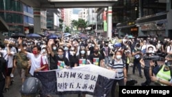 香港民主派前立法会议员朱凯迪(手持横额者左起),民阵召集人陈皓桓,社民连前立法会议员梁国雄,民主党前主席及前立法会议员胡志伟等8名民主派人士,因 今年7-1游行,12月8日被警察拘捕。(陈皓桓Facebook图片)