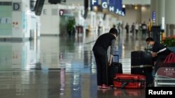 一位女乘客在香港国际机场整理行李(资料照:2020年10月20日)