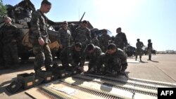 法国士兵1月16日在部署之前,在巴马科空军基地准备他们的弹药