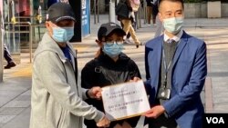 被扣押深圳港人李子贤夫亲(左)及黄伟然太太作为家属代表,12月21日向香港入境处代表递交公开信。 (美国之音/汤惠芸)